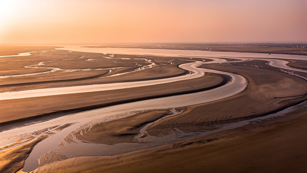 Aerial photograph of wide tidal mudflats at the Gulf of Khambhat at low tide.